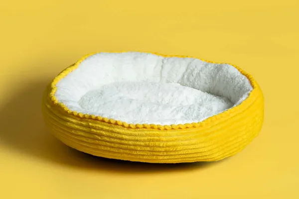 Round yellow corduroy pet bed with soft white plush interior